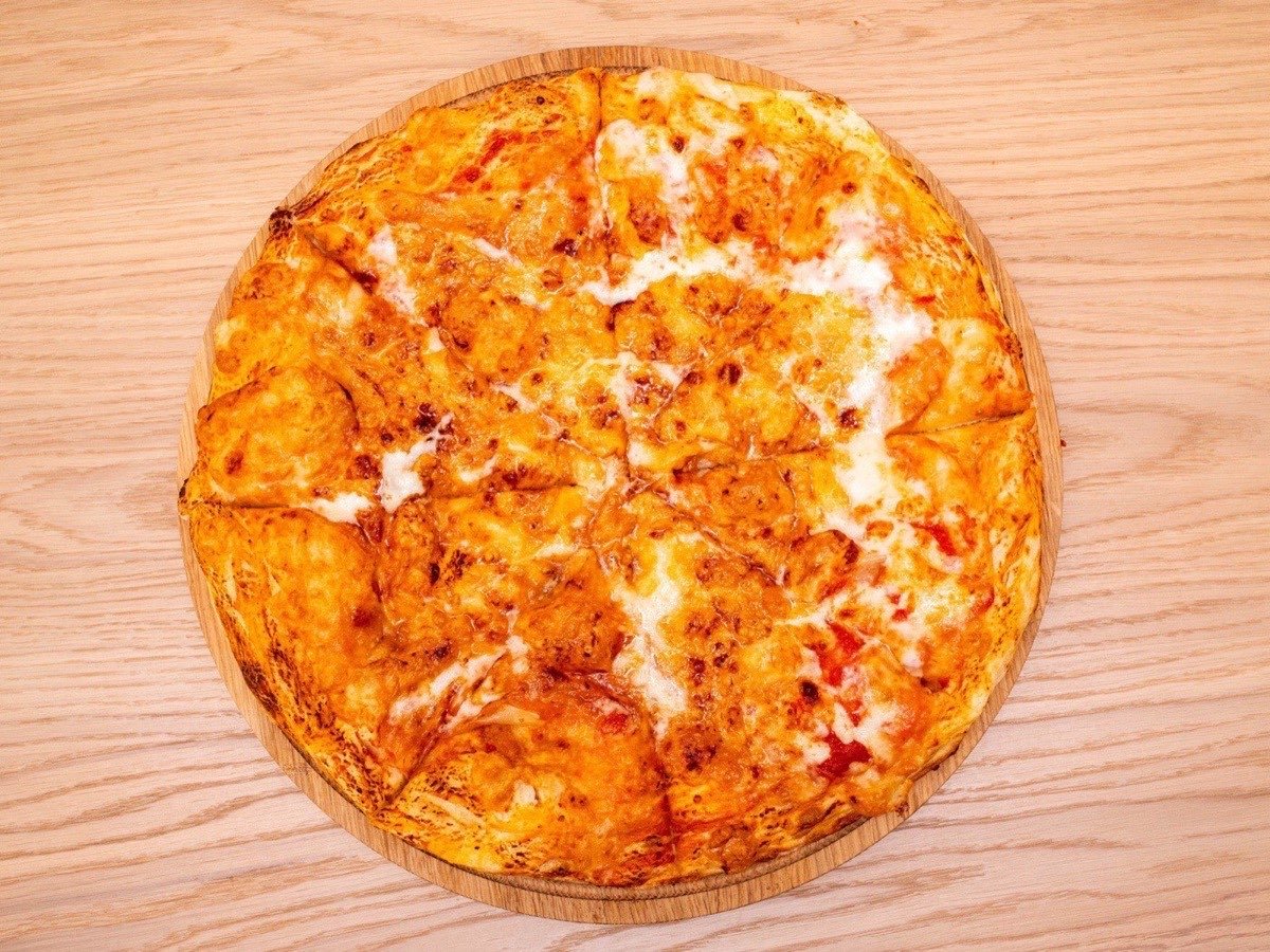 Large cheese pizza with tomatoes and olives